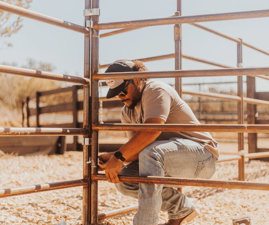 cowboy working on cattle gate ranch fence
