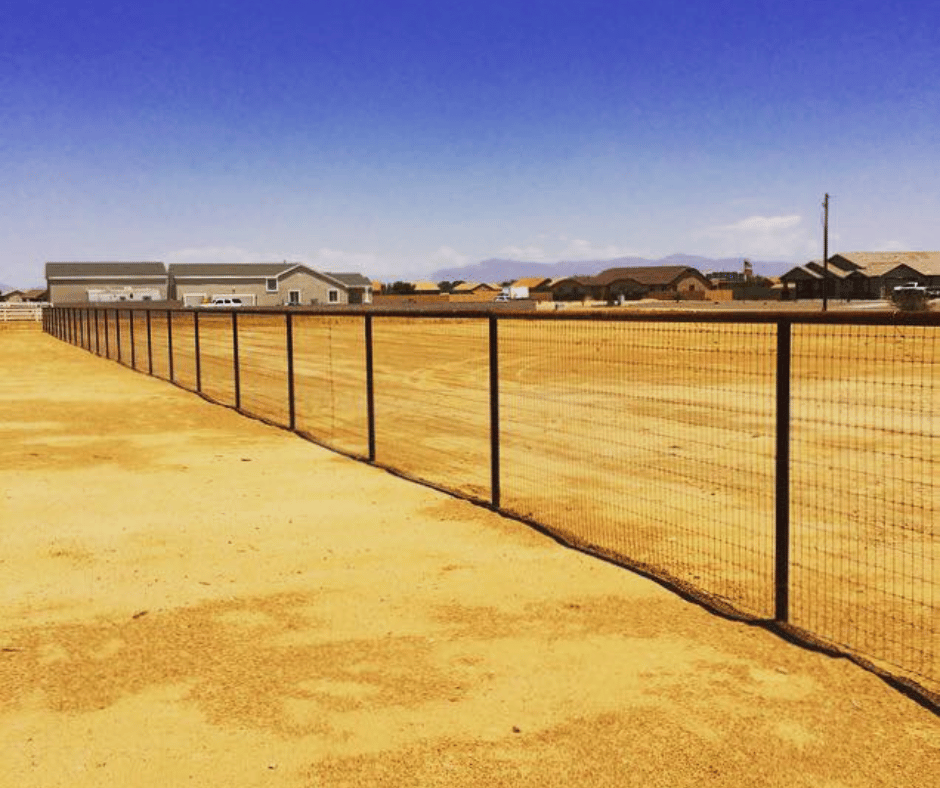 fence in dry landscape with houses in background