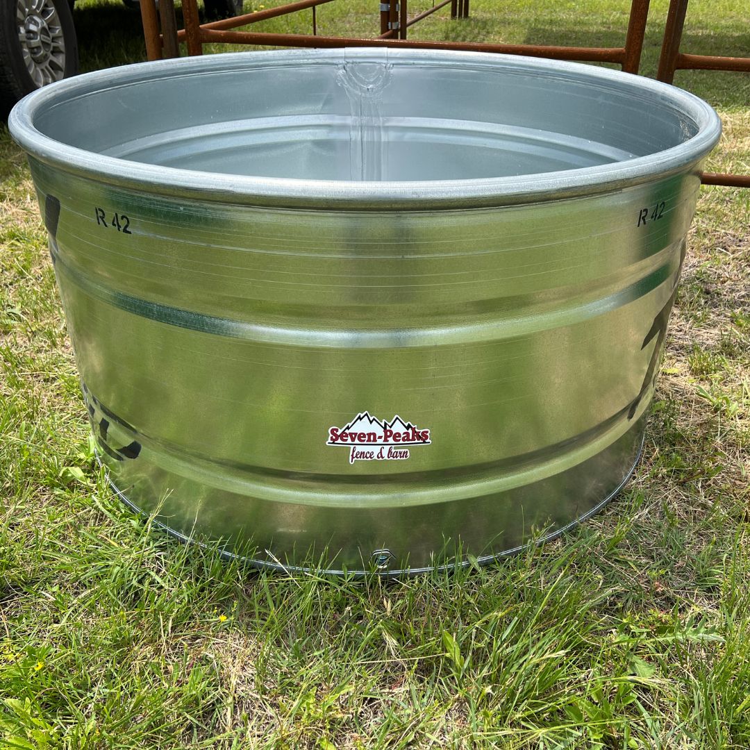 4 Foot round stock tank on grass next to livestock fencing