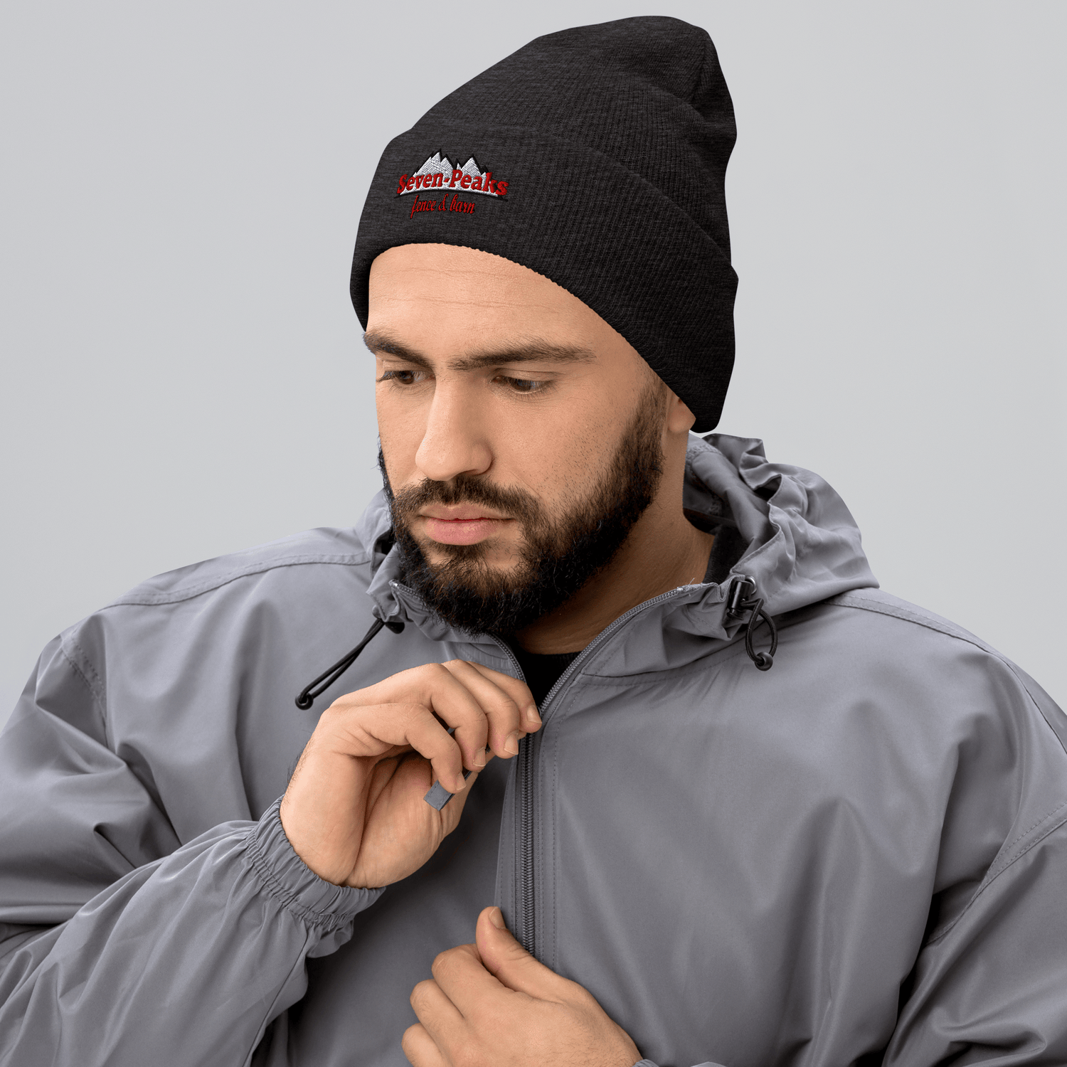 Man wearing black beanie and gray jacket.